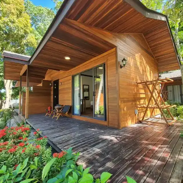 Wooden deck and entrance of a beach chalet at Borneo Divers Mabul Resort, with red flowers in front
