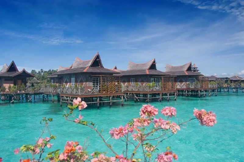 Standard Water Bungalows of Mabul Water Bungalows in a row over a turquoise lagoon